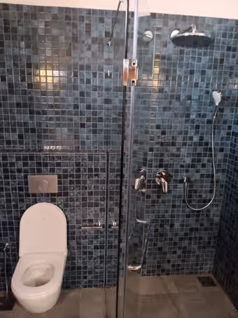 Douche en mosaïque bleu nuit avec mitigeur encastré et WC suspendu